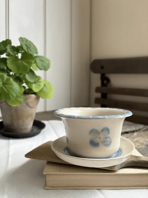 Handmade white stoneware decorative vessel from the Bloom Collection by Loopline Ceramics, hand-painted in a Wedgwood blue floral design and displayed on a matching dish.
