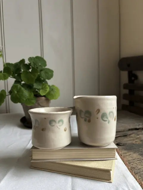 Handmade white stoneware jug and cup from the Flora Collection by Loopline Ceramics, hand-decorated in soft eucalyptus tones.